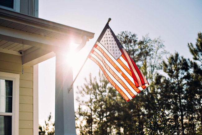 American flag hanging from a home's front porch